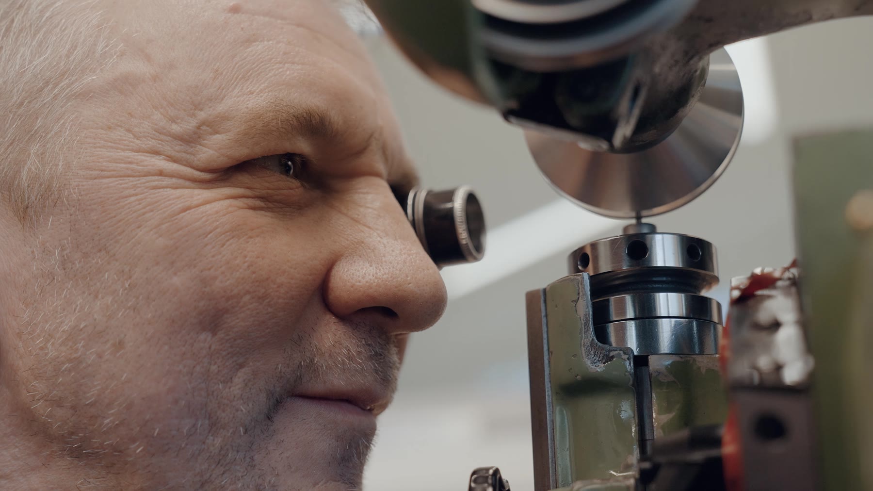 Opérateur à l’oculaire d’une machine de contrôle, en atelier